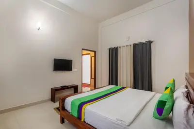 a bedroom with a bed and a flat screen tv at Treebo Vrindavan, 3 Km From Madikeri Fort in Madikeri