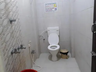 a small bathroom with a toilet in a stall at Pattiah Naidu Palace in Palani