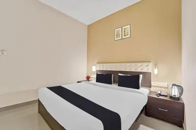 a bedroom with a large white bed with blue pillows at Collection O Kalady Near Airport in Cochin