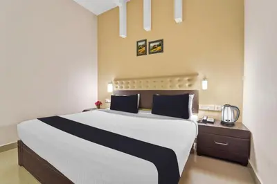 a bedroom with a large white bed with blue pillows at Collection O Kalady Near Airport in Cochin