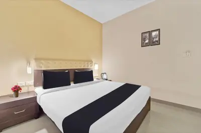 a bedroom with a large bed with blue pillows at Collection O Kalady Near Airport in Cochin