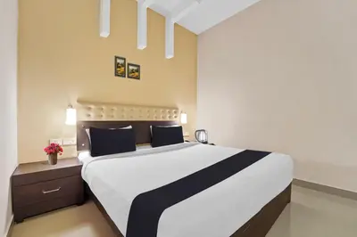 a bedroom with a large white bed with blue pillows at Collection O Kalady Near Airport in Cochin