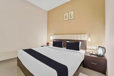 a bedroom with a large white bed with blue pillows at Collection O Kalady Near Airport in Cochin