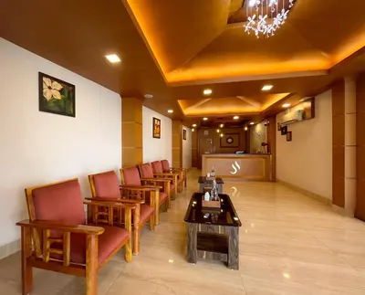 a waiting room with a row of chairs and a table at Shree Residency in Erode