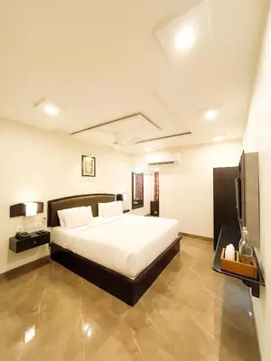 a bedroom with a large bed and a television at Shree Residency in Erode