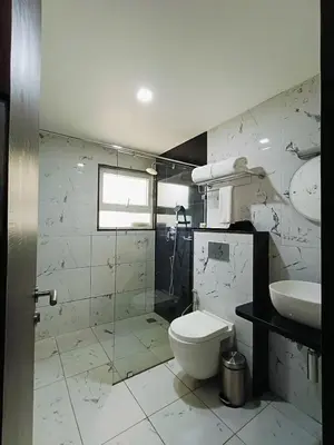 a bathroom with a toilet and a sink at Holiday Residency Coimbatore in Coimbatore