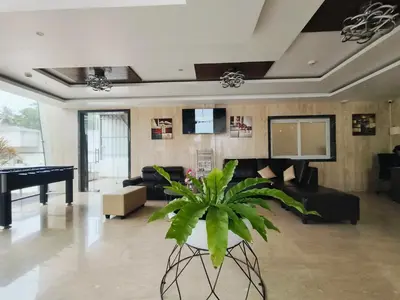a living room with a piano and a potted plant at Holiday Residency Coimbatore in Coimbatore
