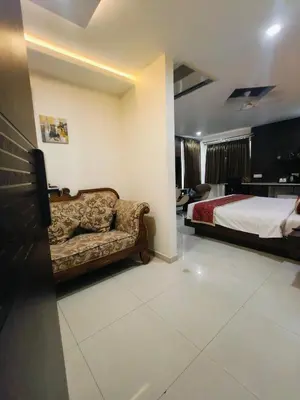 a hotel room with a bed and a couch at Holiday Residency Coimbatore in Coimbatore