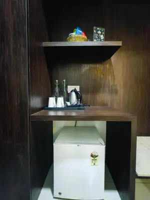 a shelf with a table on top of a refrigerator at Holiday Residency Coimbatore in Coimbatore