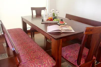 a wooden table with a book and a plate of fruit at The Xanadu, Coonoor in Coonoor