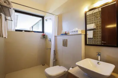 a bathroom with a sink and a toilet and a mirror at The Xanadu, Coonoor in Coonoor