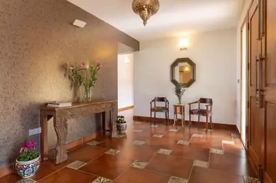 a hallway with a fireplace and a mirror and chairs at The Xanadu, Coonoor in Coonoor