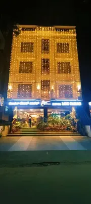 a large yellow building with lights on it at night at Hotel Lok Sagar Mysore in Mysore
