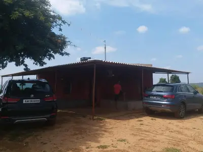 two cars parked in front of a small house at Green Peace Bheemeshwari in Halgūr