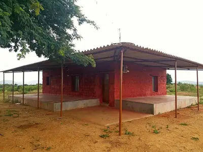 a small red brick building with a roof at Green Peace Bheemeshwari in Halgūr