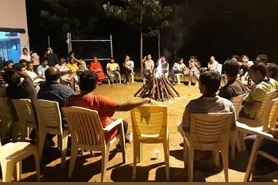 a group of people sitting in chairs watching a performance at Green Peace Bheemeshwari in Halgūr