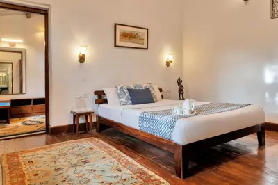 a bedroom with a large bed in a room at SaffronStays Milton Abbott Estate - 2BR colonial-era bungalow with garden, golf course views & bonfire nights near Ooty Golf Club in Ooty