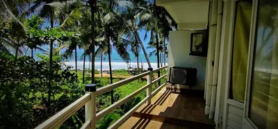 a balcony of a house with a view of the beach at White Shell Beach House in Kannur