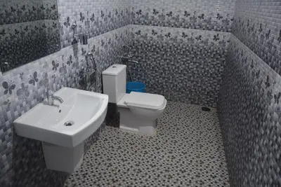 a bathroom with a white toilet and a sink at White Shell Beach House in Kannur