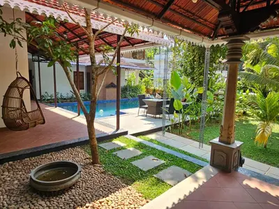 a house with a courtyard with a tree and a pool at The Isle By Area 707 in Alwaye