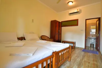 a bedroom with two twin beds and a bathroom at Cherai Onetree Retreat in Cherai Beach