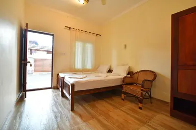a bedroom with a bed and a chair and a window at Cherai Onetree Retreat in Cherai Beach