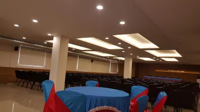 a conference room with a blue table and chairs at Nalanda Inn in Palakkad