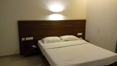 a bedroom with a bed with a light above it at Nalanda Inn in Palakkad
