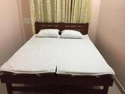 a bed with two pillows on it in a bedroom at Mega Tourist Home in Guruvāyūr
