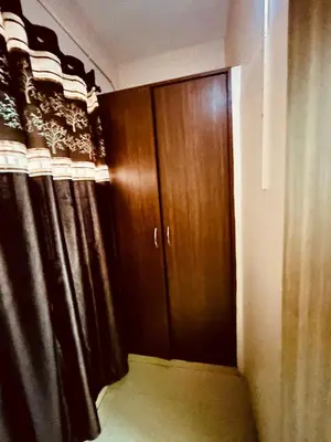 a room with a closet with wooden cabinets and a door at Hotel Jothi in Coimbatore
