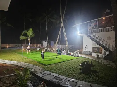 a group of people playing soccer on a lawn at night at Veda5 Ayurveda Living Village in Trichūr
