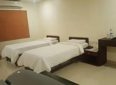 a hospital room with two beds and a sink at The Rubis in Kottakkal