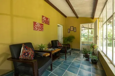 a living room with chairs and a table at The Mangifera in Bandipūr