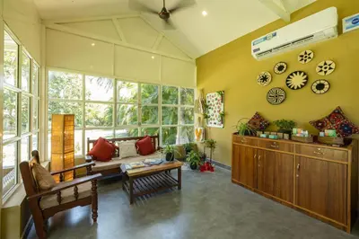 a living room with a couch and a table at The Mangifera in Bandipūr