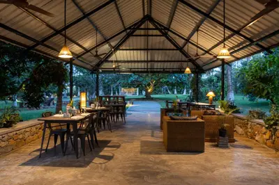 an outdoor restaurant with tables and chairs and lights at The Mangifera in Bandipūr