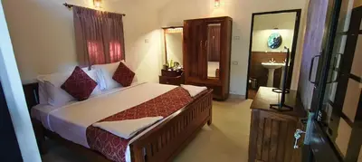 a bedroom with a bed and a bathroom with a sink at Monica Garden Bungalow in Vālpārai