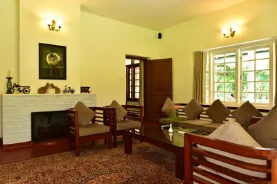 a living room with a couch and a fireplace at Monica Garden Bungalow in Vālpārai