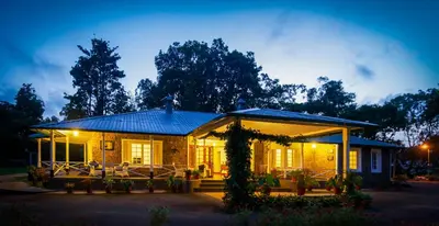 a house with a lit up porch at night at Monica Garden Bungalow in Vālpārai