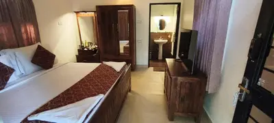 a bedroom with a bed and a sink and a mirror at Monica Garden Bungalow in Vālpārai