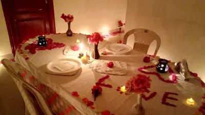 a table with a white table cloth with flowers on it at Skylarc Inn in Ooty