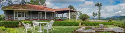a house with a table and chairs in a yard at Sirukundra Garden Bungalow in Vālpārai