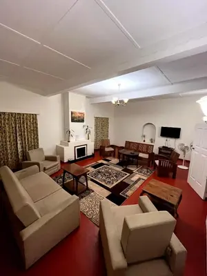 a living room with a couch and chairs and a tv at Sirukundra Garden Bungalow in Vālpārai
