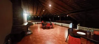 a room with tables and chairs in a restaurant at Heights Farm Stay - Coffee Estate Stay in Madikeri
