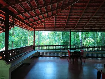 a room with a table and chairs in a forest at Heights Farm Stay - Coffee Estate Stay in Madikeri