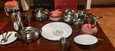 a table topped with white plates and pots and pans at Heights Farm Stay - Coffee Estate Stay in Madikeri