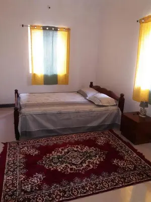 a bedroom with a bed with a rug and a window at Hill side estate in Madikeri