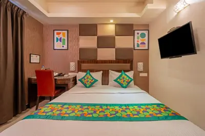 a bedroom with a bed and a desk and a television at Treebo Venition Inn in Coimbatore