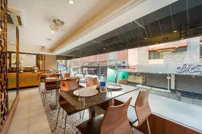 a dining room with a table and chairs at Treebo Venition Inn in Coimbatore