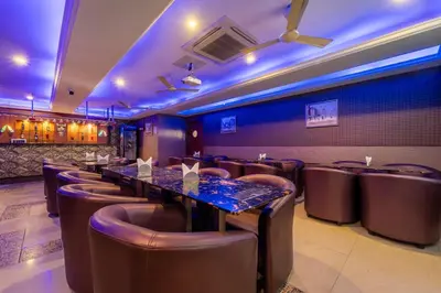 a restaurant with long tables and leather chairs at Treebo Venition Inn in Coimbatore