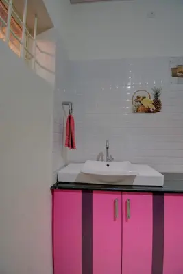 a bathroom with pink cabinets and a sink at Srinikethana Home Stay with Swimming Pool in Madikeri
